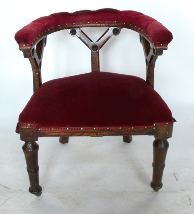 A Victorian oak and upholstered Gothic style chair, with curved back rail and Gothic style supports