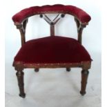 A Victorian oak and upholstered Gothic style chair, with curved back rail and Gothic style supports