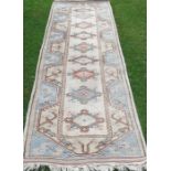 An Eastern design runner, decorated with triangular lozenges to the pale ground, 34ins x 112ins