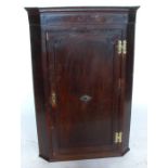 An Antique oak corner cabinet, the fielded door opening to reveal three shaped shelves, height 48.
