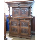 An Antique style carved oak cabinet, the upper section fitted with a pair of cupboard doors,
