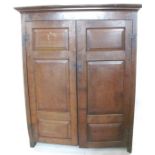 An Antique oak cupboard, the pair of fielded doors opening to reveal a hanging space, width 55ins,