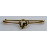 A 9 carat gold bar brooch, Birmingham 1902, set with a trio of seed pearls within a lovers knott,