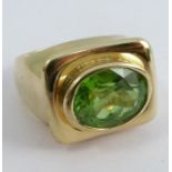 A single stone peridot ring, stamped '750', finger size N 1/2, 13g gross
