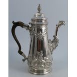A George II silver coffee pot, with embossed floral and scroll decoration, the spout decorated