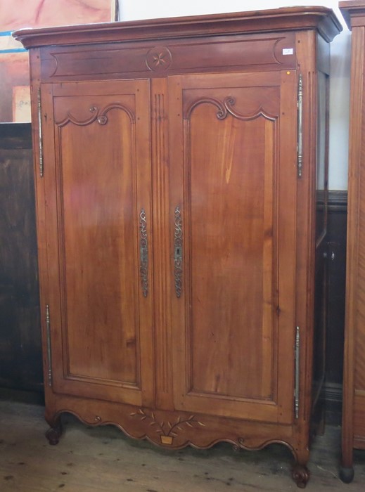 A Continental walnut inlaid armoire, fitted with doors and having inlaid star motif