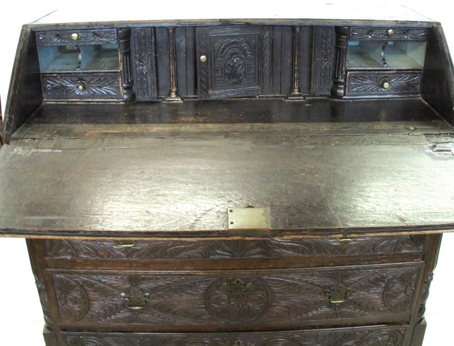 An Antique dark oak carved bureau, the fall flap opening to reveal drawers, cupboard and pigeon - Image 2 of 4