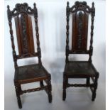 A pair of Antique oak high back chairs, with carved decoration, with leather cover to the solid