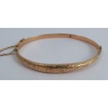 A 9 carat gold hinged bangle, 5.2g gross