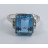 An aquamarine and diamond ring, stamped '585' to the white mount, the step cut stone 11.3 by 9.3