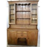 A pine dresser, the upper section having a pair of glazed doors with shelves in between, the base