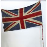 A linen Union Jack, mounted on a brass carrying pole with a gilt finial