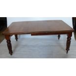 A 19th century mahogany dining table, with one leaf, raised on turned reeded legs, 69ins x 49.5ins x