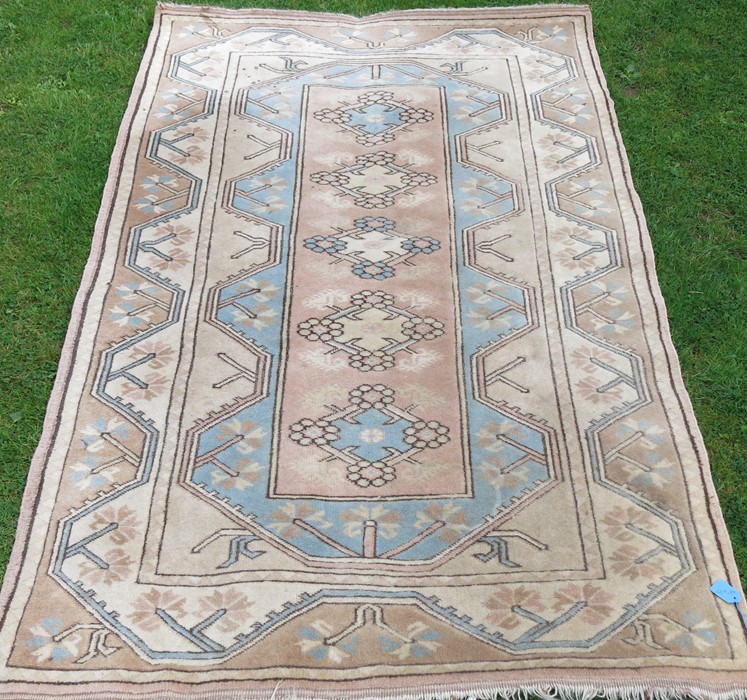 An Eastern design rug, decorated with triangular lozenges to the pale ground, 48ins x 77ins