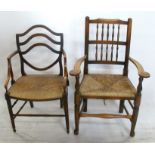 An Antique beech open arm chair, with shield shape back, having a rush seat with turned