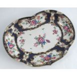 An 18th century Worcester shaped oval dish, decorated with gilt framed reserves of flowers to a
