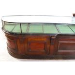 A 19th century shop counter, with glazed display top over a panelled base with one curved end, 77ins