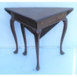 A 19th century mahogany triangular fold over table, raised on three scroll legs on pad feet, width