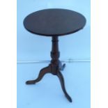 An Antique oak occasional table, the circular tilt top raised on a turned column with three outswept