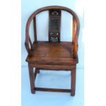 An Oriental hardwood open arm chair, with shaped back and carved splat over a solid seat