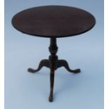 A 19th century oak tripod table, the tilt top raised on a turned column to three outswept
