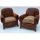 A pair of 20th century leather upholstered armchairs, with carved oak front rail and front supports