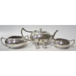 A Silver Plated Three Part Tea Set with hammered effect decoration and a pair of barrel peppers