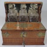 A Victorian Oak and Brass Mounted Three Bottle Tantalus