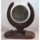An Indian Carved Wooden Table Gong decorated with foliate work and the gong with regional map,
