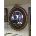 A Large Oval Mirror with plush and gilt gesso frame