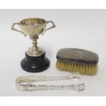 A Pair of Sterling Silver Sugar Tongs, presentation cup and silver backed brush, 66g weighable