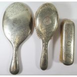 An Edward VII Silver Backed Three Part Hand Mirror and Brush Set with chased foliate scroll