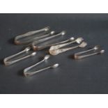 A Pair of Chester Bright Cut Silver Sugar Tongs, four other pairs of sterling silver tongs (112g)