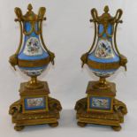 A pair of hand painted gilt brass and porcelain clock garniture,