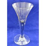 A late Georgian wine glass with trumpet bowl, the stem with single tear-shaped bubble,