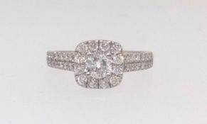 A platinum and diamond set cluster ring enhanced with two channels of diamonds to the shoulders, the