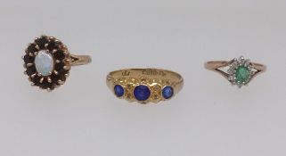 A 9ct opal cluster ring, an 18ct antique three stone sapphire ring, size U and a 9ct dress ring (