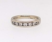 An 18ct white gold and diamond channel set eternity ring, size K, with original purchase receipt