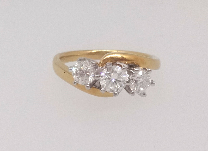 An 18ct diamond three stone ring in yellow gold set with three round brilliant cut diamonds, total