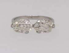 A platinum two stone diamond ring set with two oval cut diamonds, total weight approx 2.74ct, one
