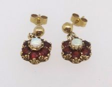 A pair of garnet and opal cluster earrings set in yellow metal.