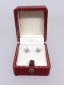 A pair of diamond stud earrings.