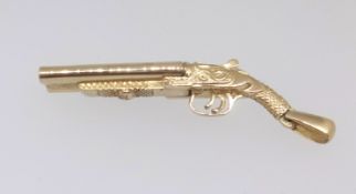 A 9ct gold shotgun charm with hinge barrel and two removable cartridges, approx 31.5gms, length