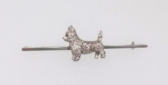A brooch surmounted with West Highland Scottie set with diamonds, the brooch stamped 15 and 18ct