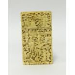 An antique carved ivory card case, deeply carved on all sides with figures, trees and buildings,