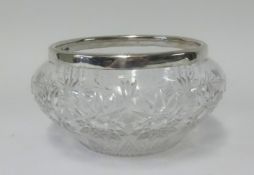 A glass fruit bowl with silver mounted rim.