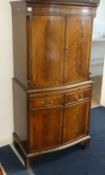 A Reprodux mahogany cocktail cabinet made by Bevan & Funnell Ltd with a light, glass shelves and