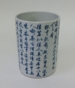 An Oriental porcelain brush pot decorated in blue and white with script, height 16cm.