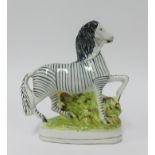 A Staffordshire style flat back figure of a Zebra, height 21cm.