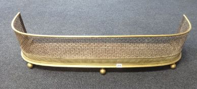 A Victorian pierced brass curbed fender, length approx 107cm.